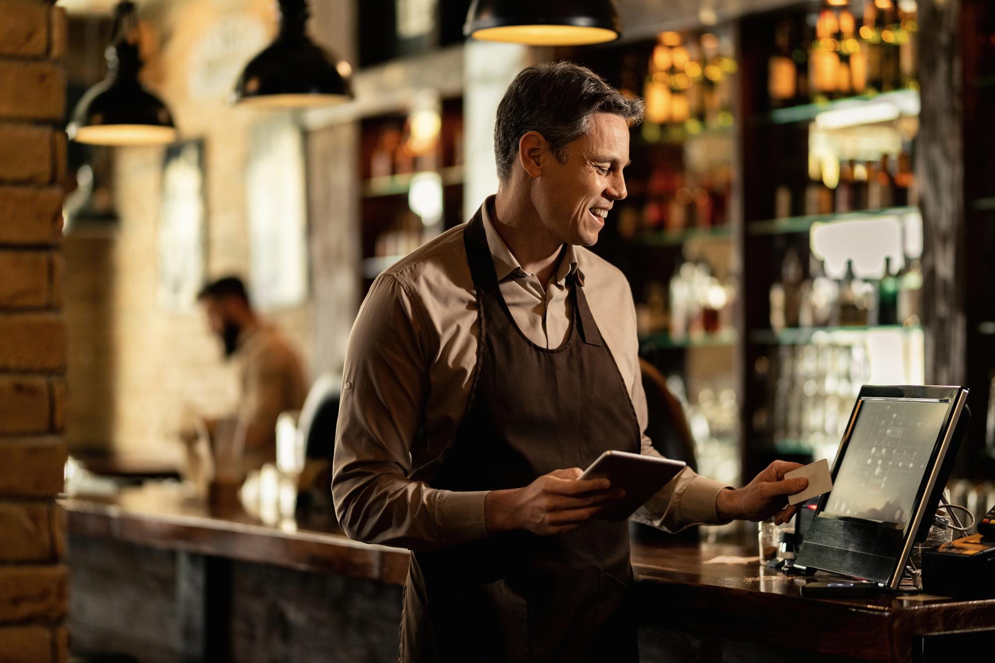 Restaurant staff processing a card payment at a point-of-sale terminal